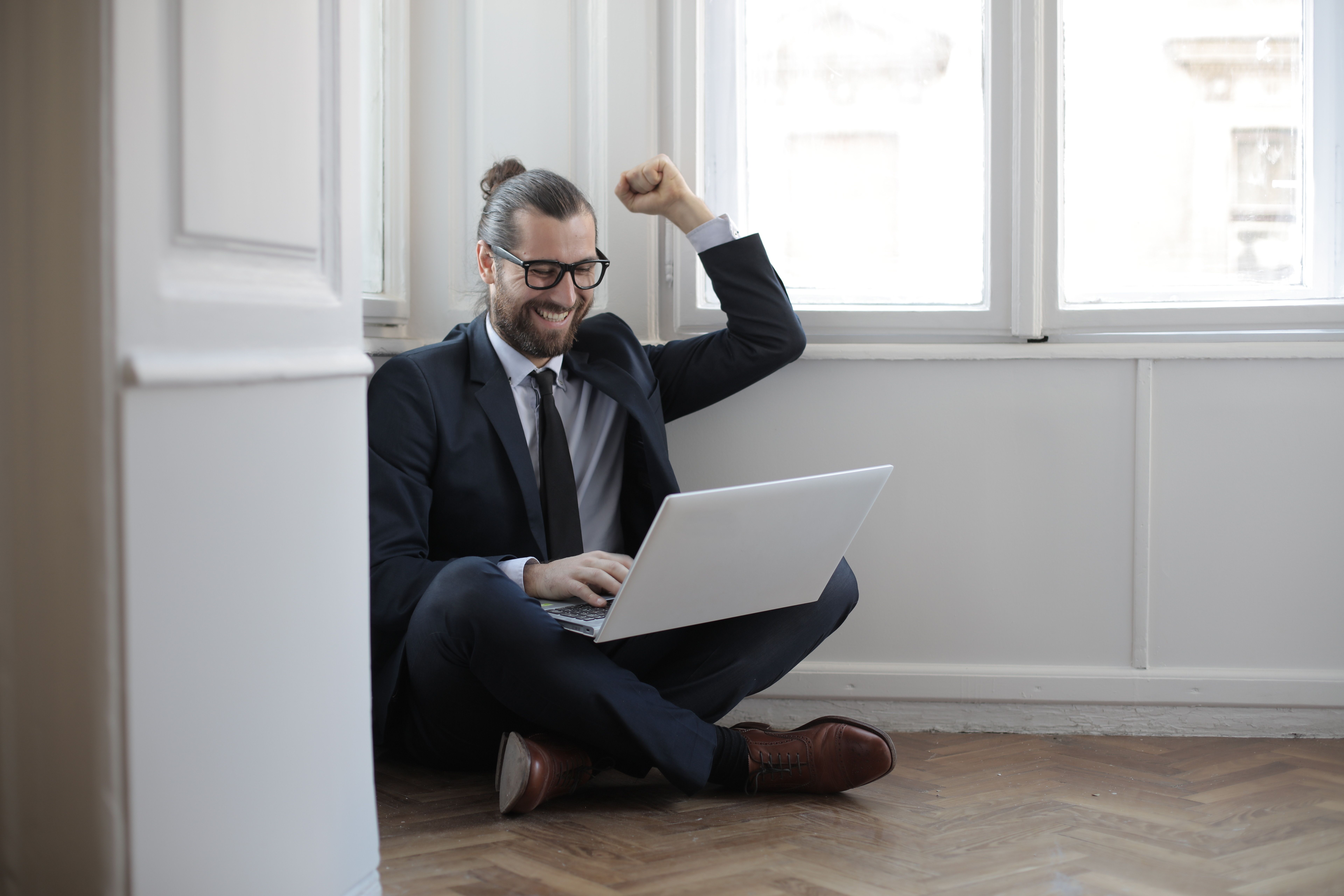 Fachkraft im Finanzwesen freut sich am Laptop über eine neue Karrierechance durch passive Jobsuche