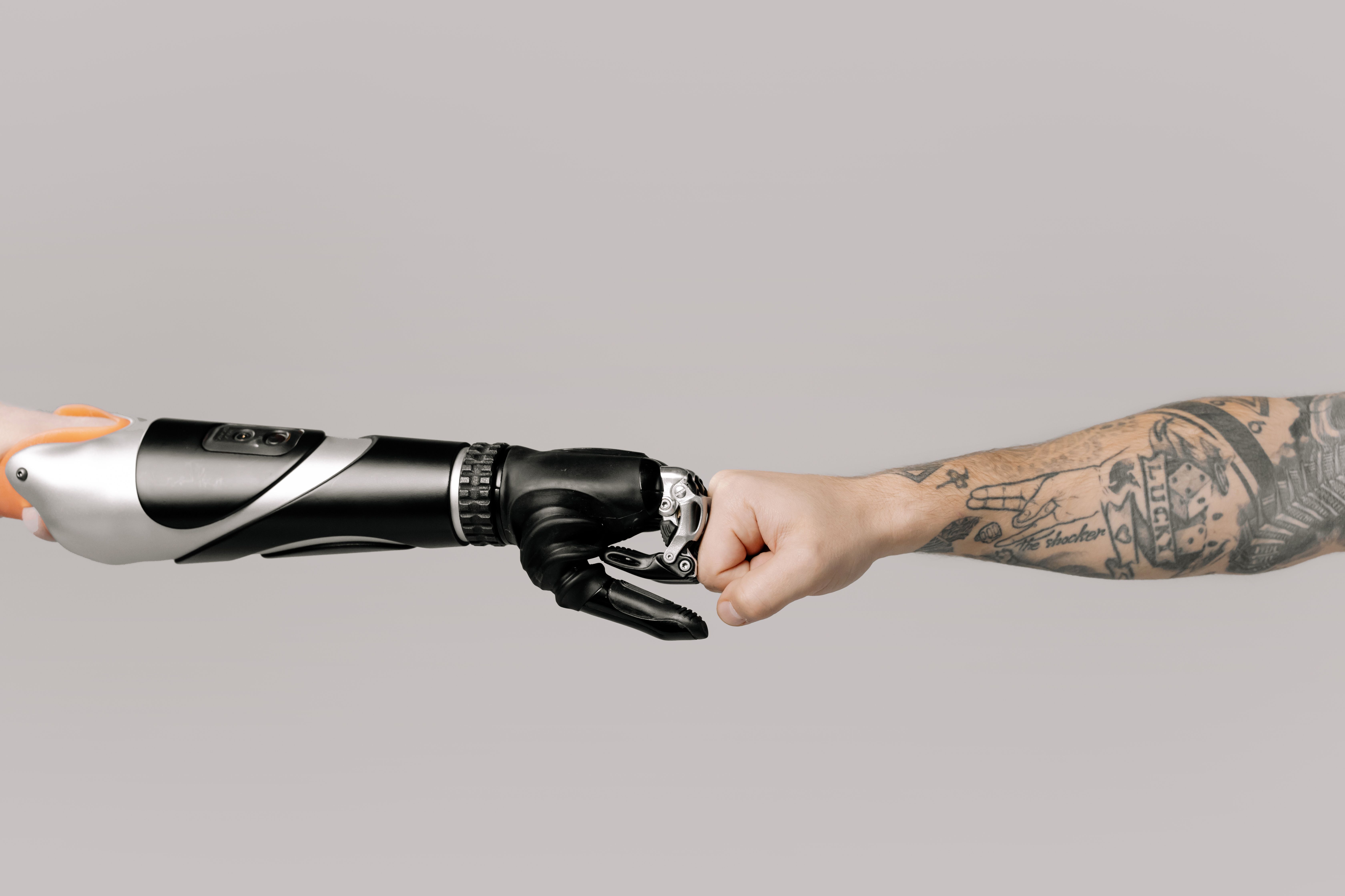Roboterhand und menschliche Hand im Fist Bump als Symbol für das Zusammenspiel von KI und Mensch im Recruiting